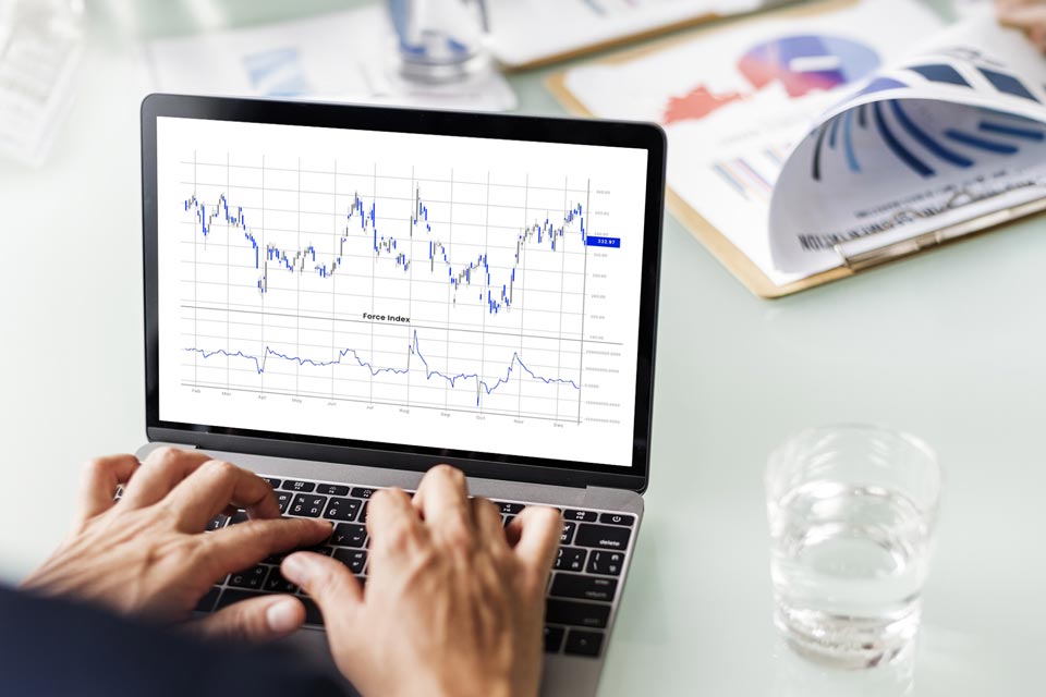 Person analyzing a trading chart with the Force Index indicator displayed on a laptop screen, illustrating how to use the Force Index indicator in forex.