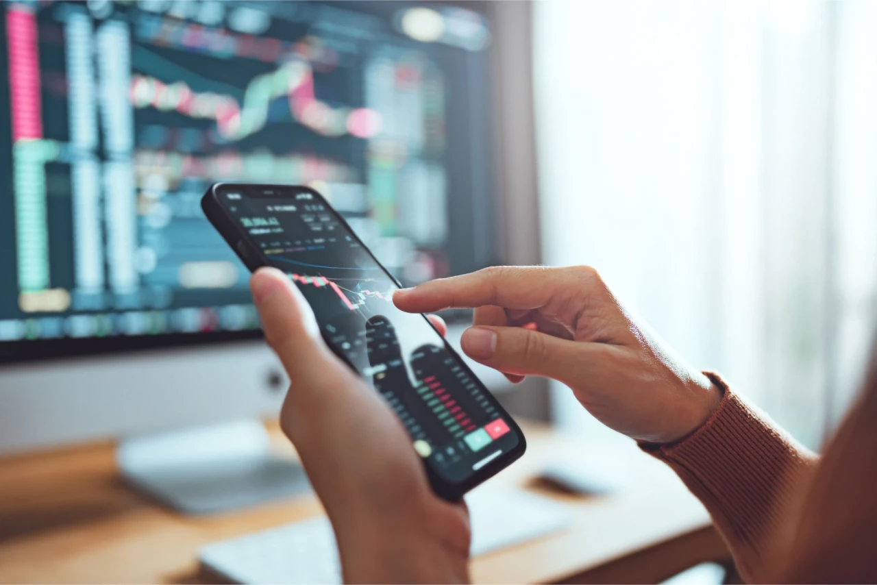 Mobile phone showing real-time trading activity, illustrating the concept of understanding forex rollover rates.